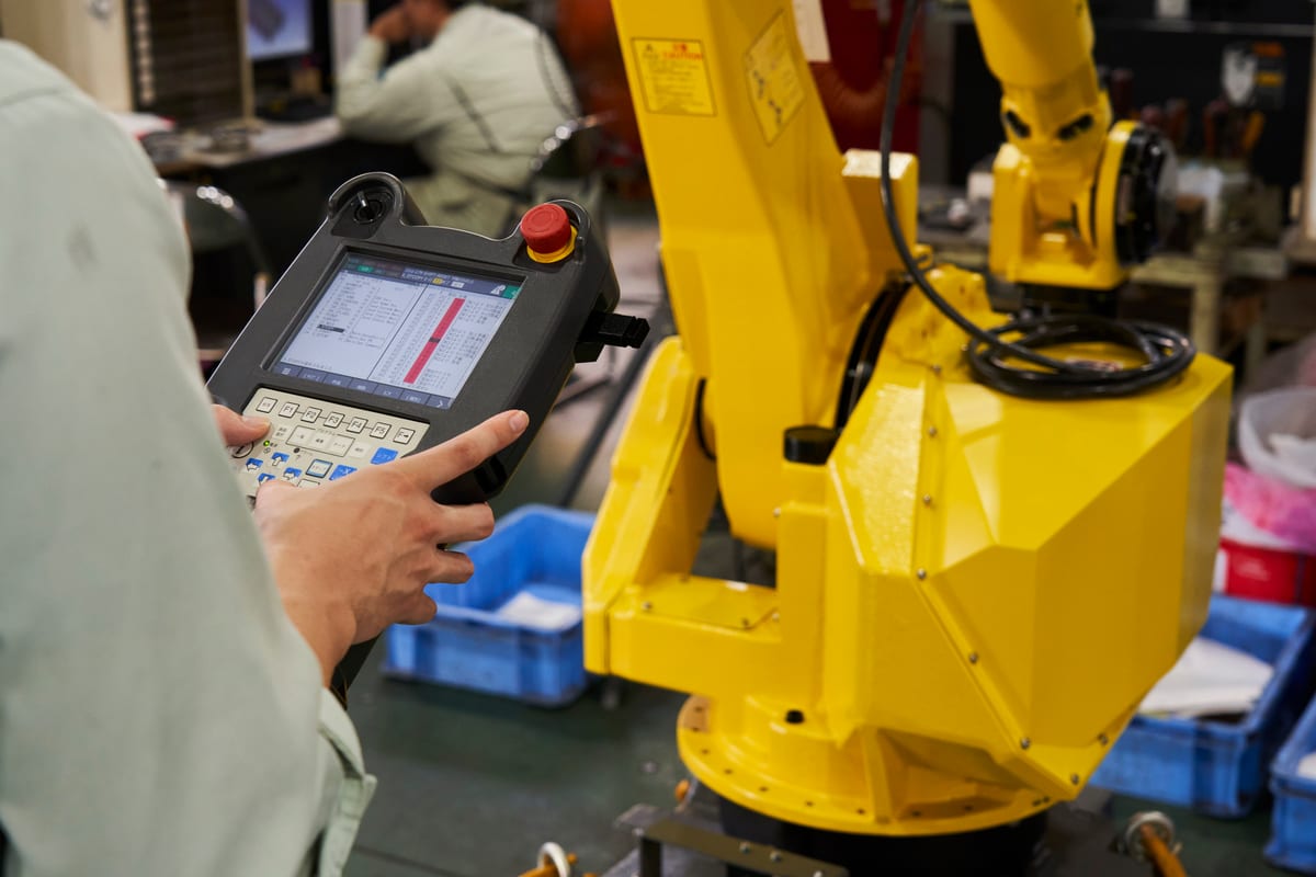 産業用ロボットのティーチングペンダントを操作する様子