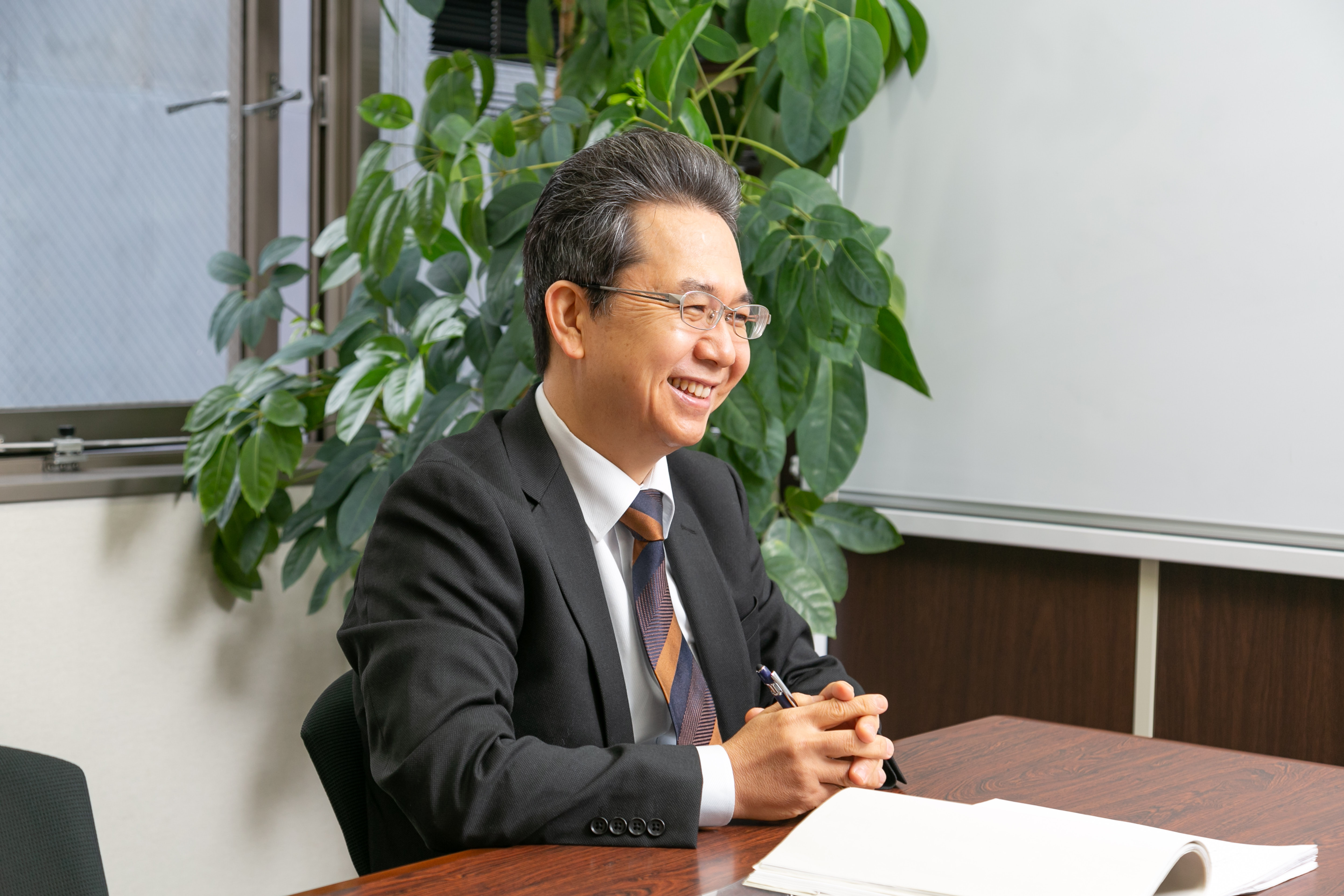 机に向かい笑顔でインタビューに応じる川原一紀さん