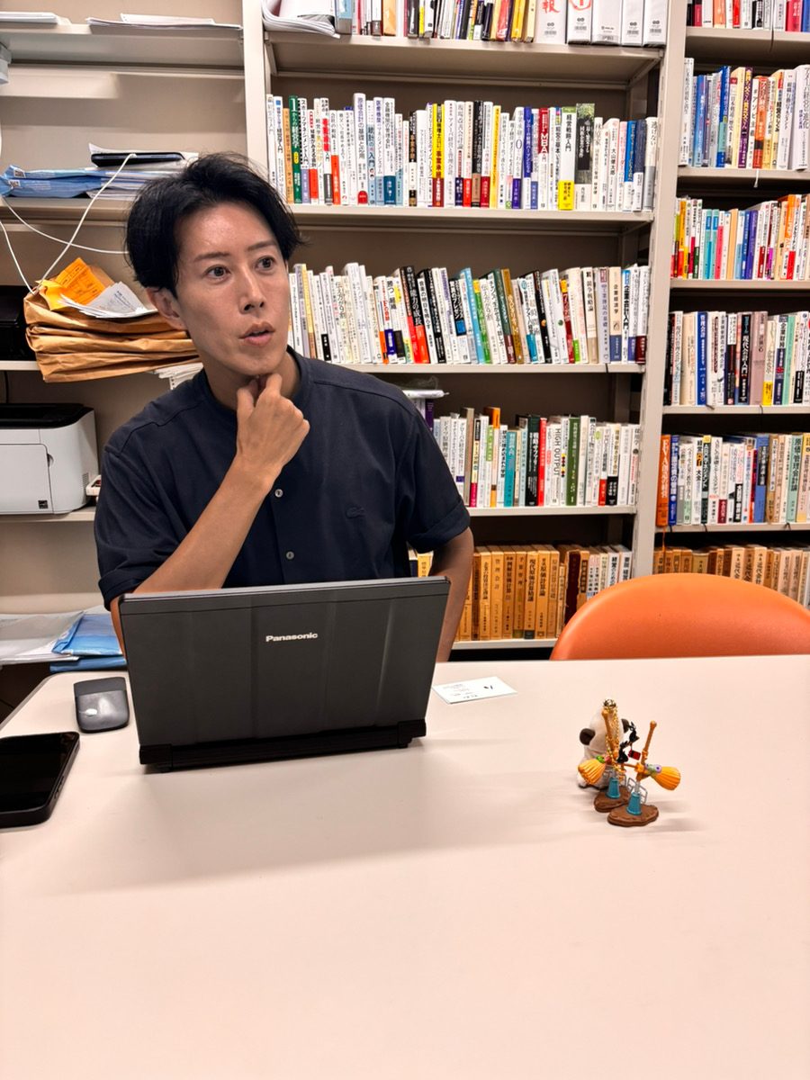 研究室で身ぶりを交えて語る近藤大輔教授