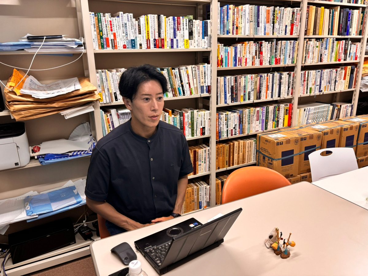 テーブル越しにインタビューに応じる近藤大輔教授